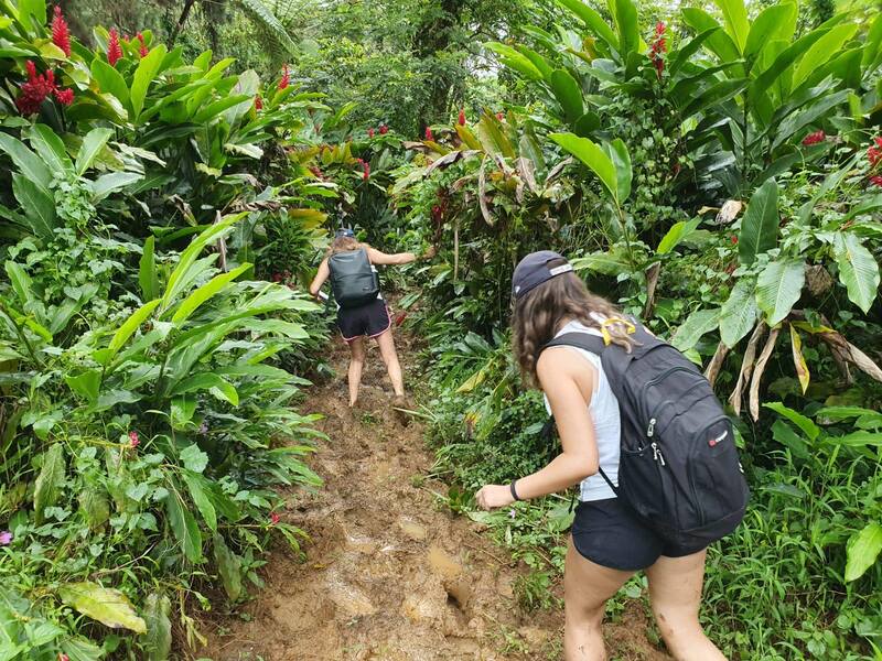 Two woman going through a muddy section of the trail at Lake Lanoto'o Samoa.